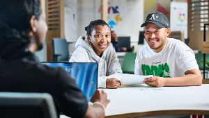 two students sat having a conversation with a student advisor