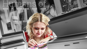 Charlotte Dunn sitting at a desk working on some art, her surroundings in black and white with text reading Humans of WLV