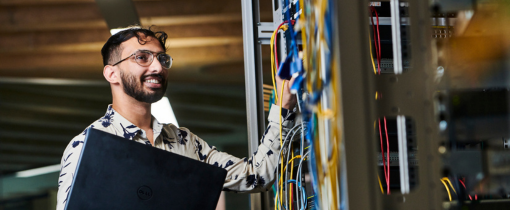 Student smiling and holding laptop