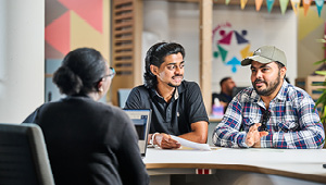 two students sat having a conversation with a student advisor